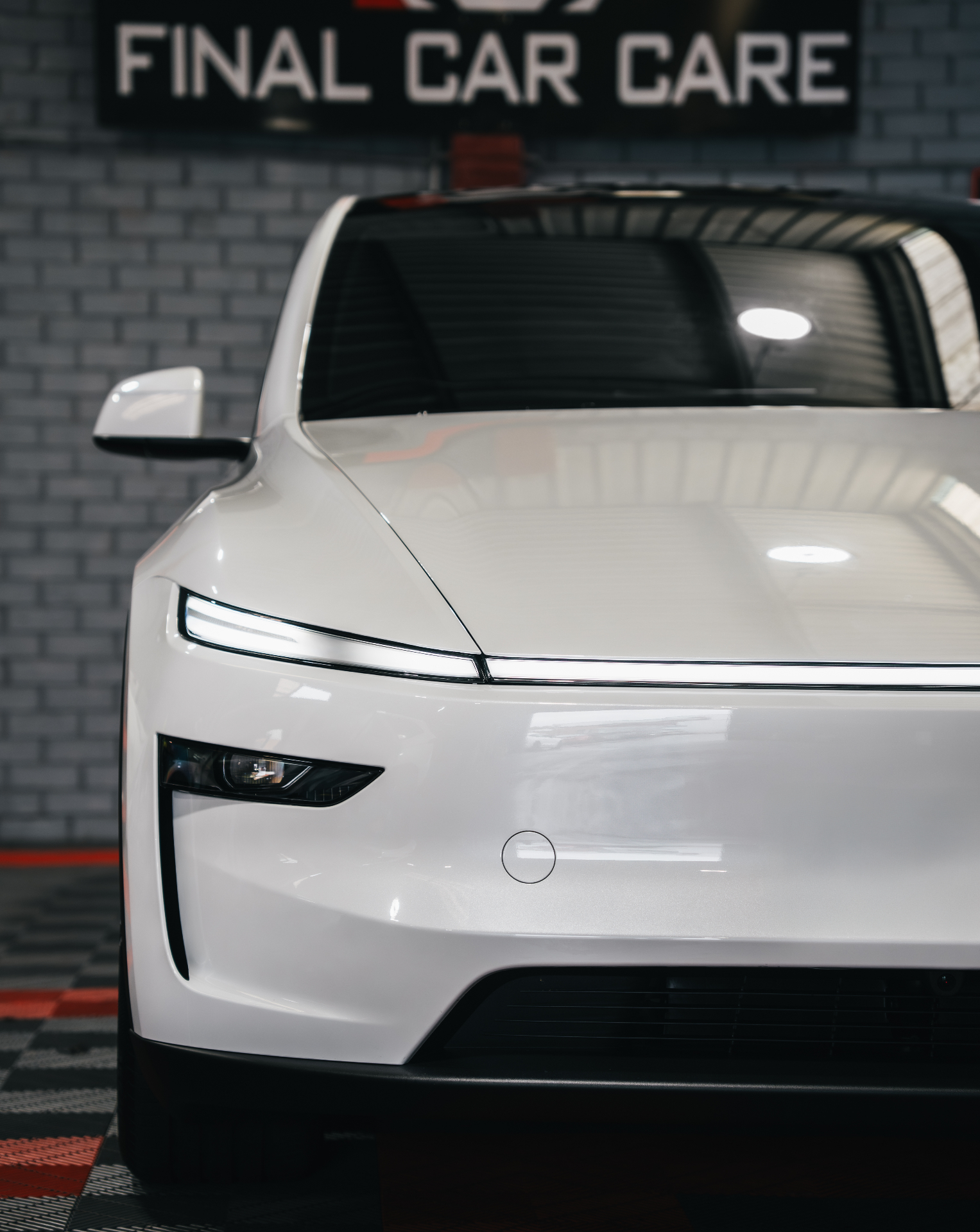 White Tesla front under Final Car Care sign